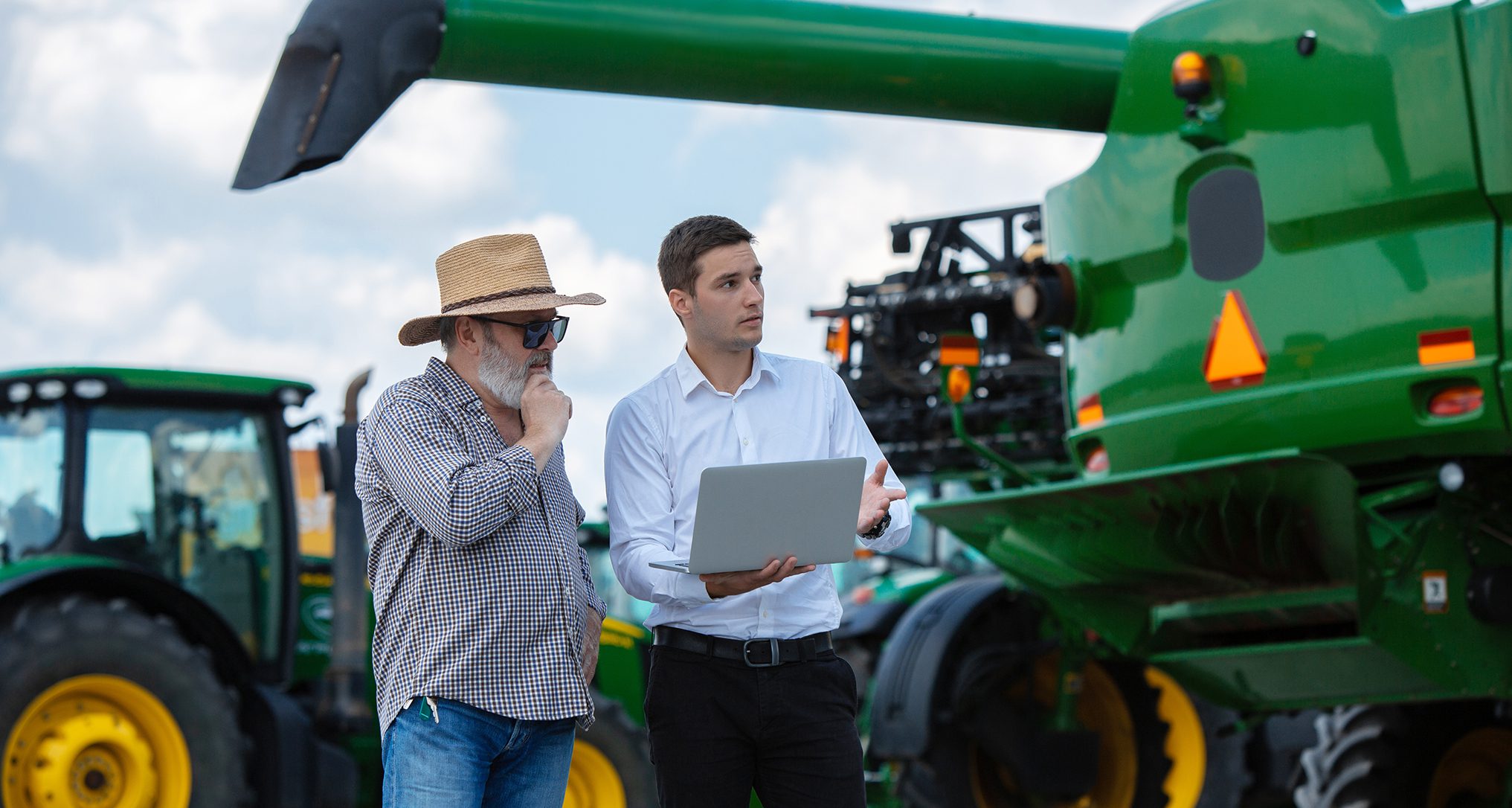 tech with farmer diagnosing farm equipment